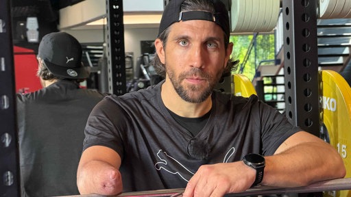 Mann lehnt auf Fitnessgerät