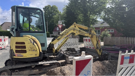 ein gelber Bagger arbeitet an der Baustelle