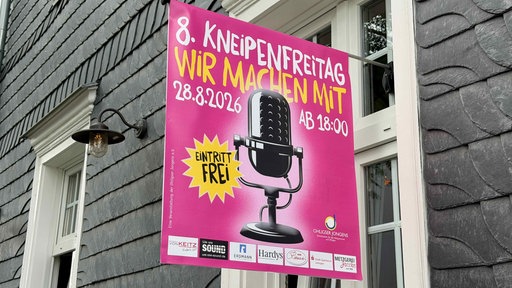 Veranstaltungsplakat an einer Hauswand