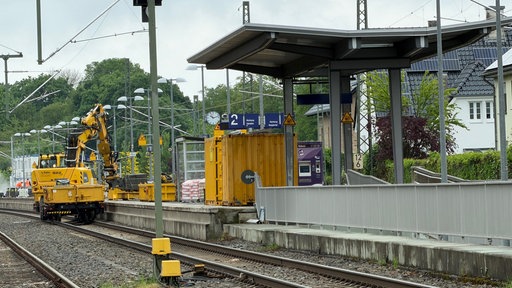 Baufahrzeuge auf Bahngleisen am Bahnsteig