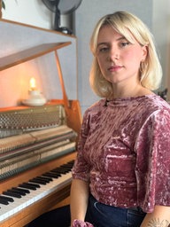 Leonora sitzt vor einem Klavier