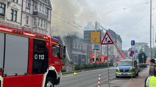 ausgebrannter Dachstuhl eines Hauses in der Inenstadt aus dem Rauch emporsteigt 