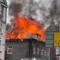 Brennender Dachstuhl eines Hauses in der Innenstadt aus dem Rauch und Feuer emporsteigt 