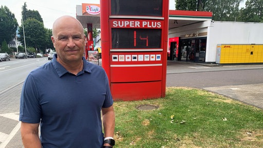 Reporter Christian Licht steht vor einer Tankstelle