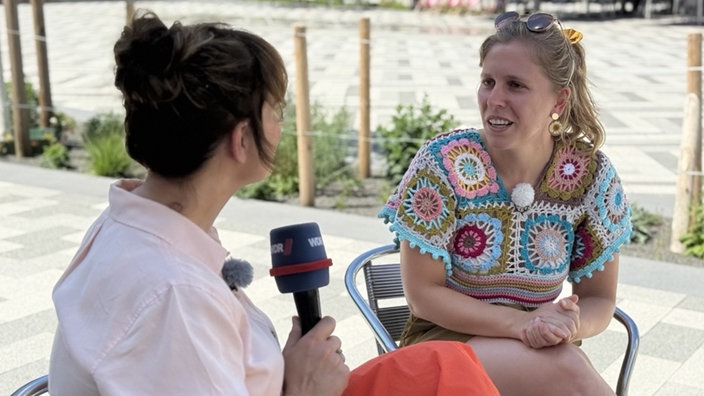 Frau spricht mit anderer Frau in buntem Top