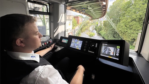 Schwebebahnfahrer sitzt am Steuer