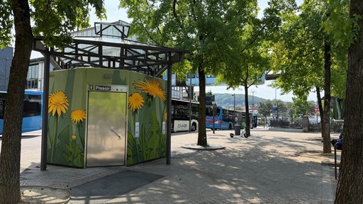 Die Öffentliche Toilette am Berliner Platz in Wuppertal Oberbarmen, im Hintergrund Busse und die Schwebebahn