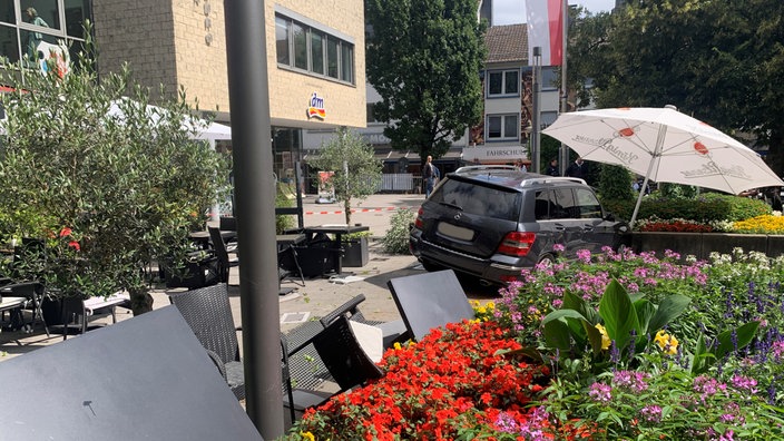 Großes graues Auto steht im Außenbereich einer Gastronomie
