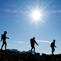 Wuppertaler Bergsteiger auf einem Gipfel im Gegenlicht
