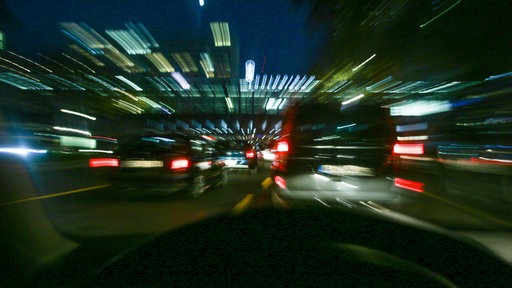 Autos rasen nachts durch die Stadt.