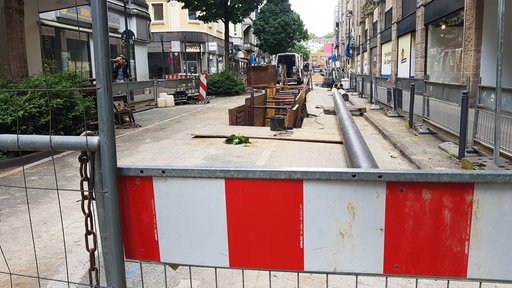 Bauarbeiten auf einer Strasse, Baumaterial liegen links und rechts neben der Baustelle