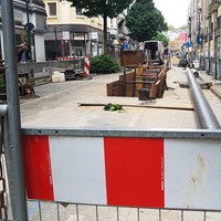 Bauarbeiten auf einer Strasse, Baumaterial liegen links und rechts neben der Baustelle