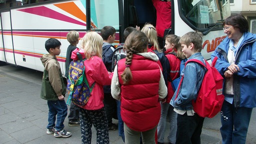  Symbolbild: Viele Kinder vor einem Reisebus.