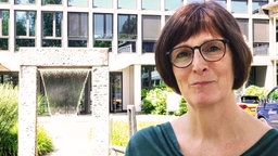 Frau vor Brunnen und Haus von Wupperverband