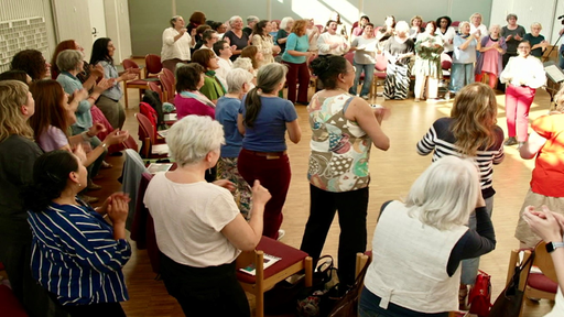 Frauen stehen zusammen und klatschen und singen