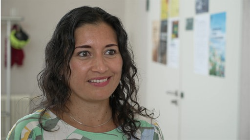 Frau mit lockigen Haaren lächelt 