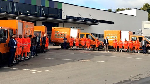 Gruppe von Mitarbeitern vor Entsorgungswägen