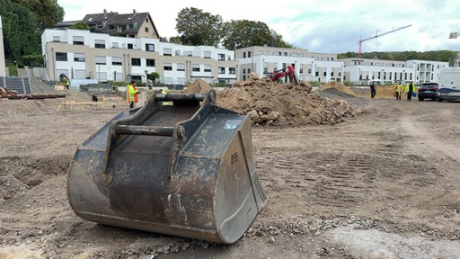 Neuer Gebäudekomplex an der Nordbahntrasse. Im Vordergrund viel Sand und eine Baggerschaufel