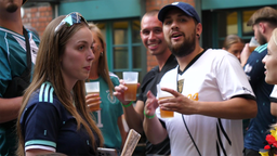 Besucher mit Bier in der Hand stehen im Außenbereich des Barmer Brauhaus