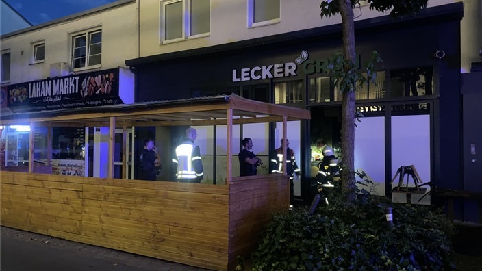 Einsatzkräfte, die vor einem Lokal stehen, wo es gerade gebrannt hat