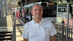 Ein Schwebebahnfahrer steht an der Haltestelle
