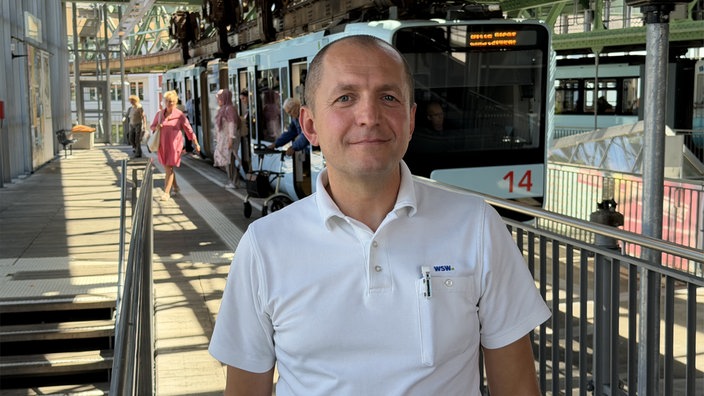 Ein Schwebebahnfahrer steht an der Haltestelle