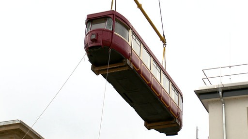 Wuppertaler Schwebebahnwagen wird mit einem Kran in die Fassade des Hauptbahnhofs eingebaut