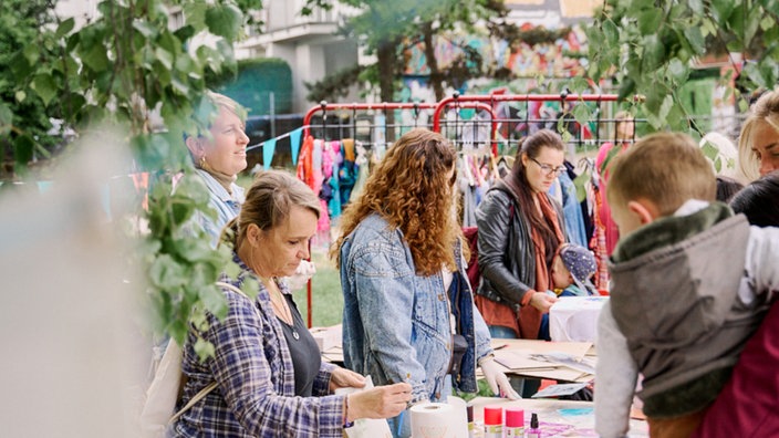 Menschen stehen an einem Tisch in einem Garten
