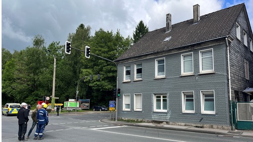 Ein graues Wohnhaus an einer Straße.