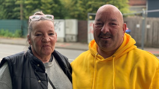 Mann und Frau stehen nebeneinander und schauen in die Kamera
