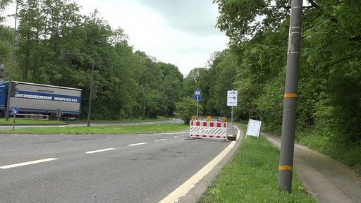 Straße mit Absperrung und Sackgassenschild