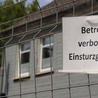 Zu sehen ist ein Schild "Betreten verboten! Einsturzgefahr!", das am Zaun hängt.