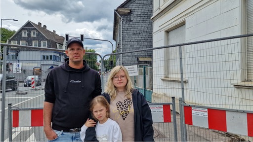 Familie Ils mit Kind, guckt traurig in die Kamera