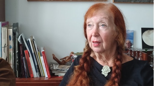 Frau mit roten Haaren in Frontalansicht schaut in die Kamera