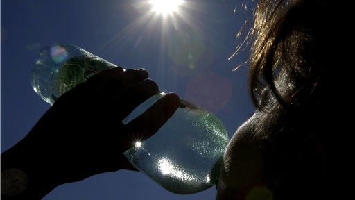 Ein Frau trinkt aus einer Mineralwasserflasche 