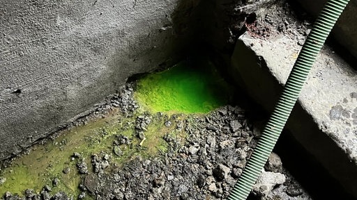 Neongelbes Wasser im Keller des unterspültes Hauses