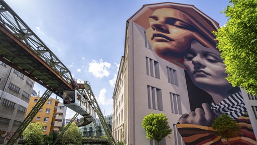 Wandbild an einer Hauswand in Wuppertal links von der Schwebebahn