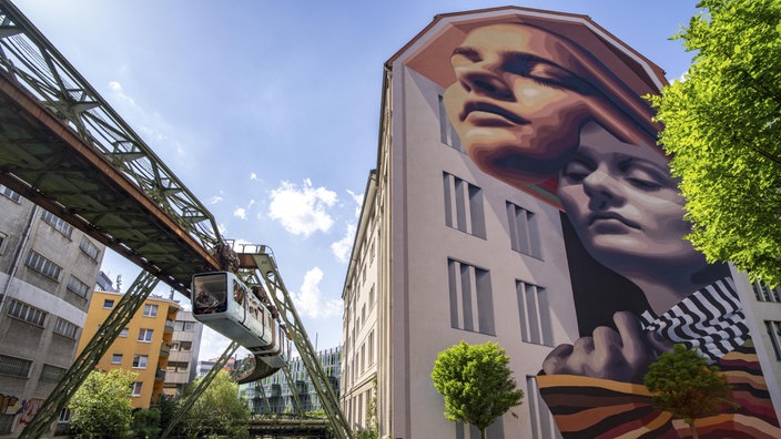 Wandbild an einer Hauswand in Wuppertal links von der Schwebebahn