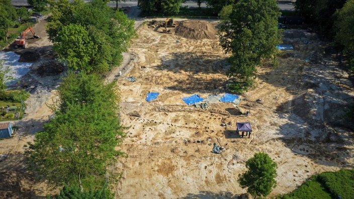 Luftbild der Ausgrabungsfläche, darauf verschiedene Gruben und Planen.