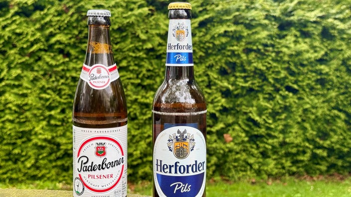Zwei Bierflaschen des Paderborner und Herforder Pils