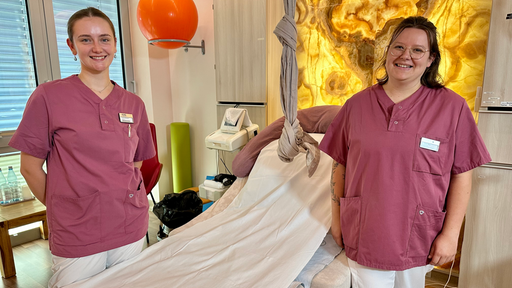 Zwei Hebammen stehen neben einem Kreißsaal-Bett