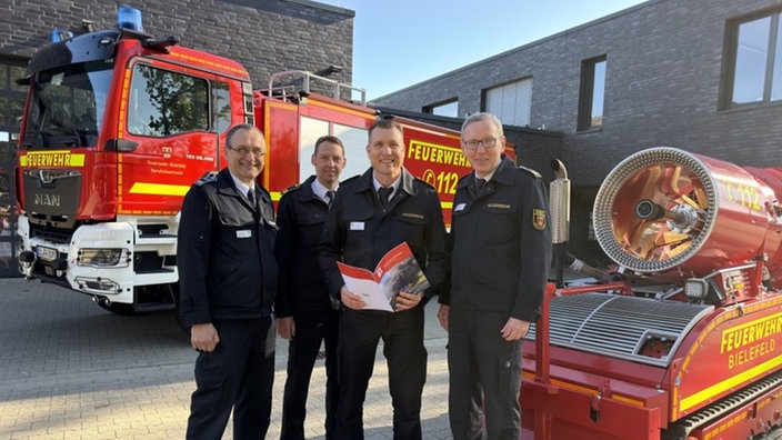 Feuerwehrmänner vor Feuerwehrautos