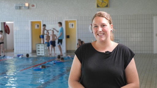 Schwimmtrainerin Katja Löppenberg steht am Beckenrand.