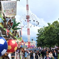 Menschen laufen vor dem Kettenkarussel auf dem Leinewebermarkt entlang