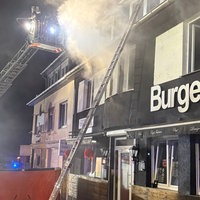 Starker Rauch kommt aus einem Haus in Löhne. Feuerwehrleute stehen auf einer Drehleiter und löschen den Brand.