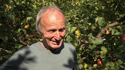 Hans-Joachim Bannier vor einem Apfelbaum