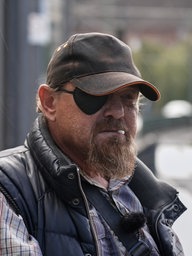 Eugen sitzt an einer Bahn-Haltestelle