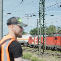 Lokführer René Breuer steht am Gleis, im Hintergrund sieht man einen Zug