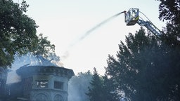 Eine Drehleiter bekaempf einen Gebaeudebrand
