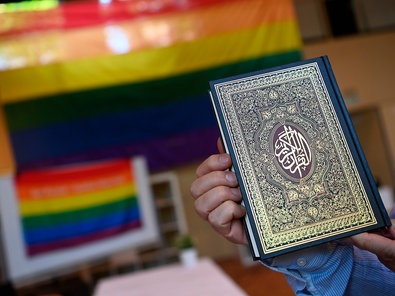 Ein Koran vor einer Prideflagge